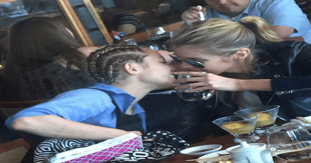 Sonriendo se van acercando para besarse Miley Cyrus y Stella Maxwell acercandose